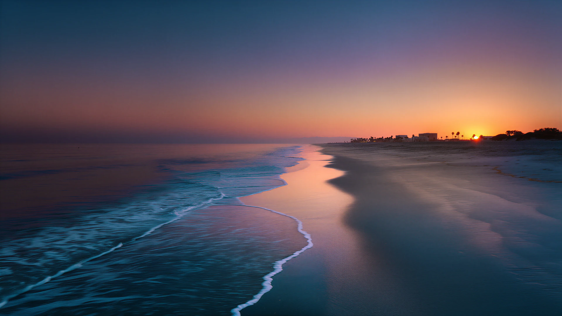 A tranquil Pacific tide glides across reflective Santa Monica sand beneath a fading peach-and-blue sky. A serene coastal wallpaper for quiet moments.