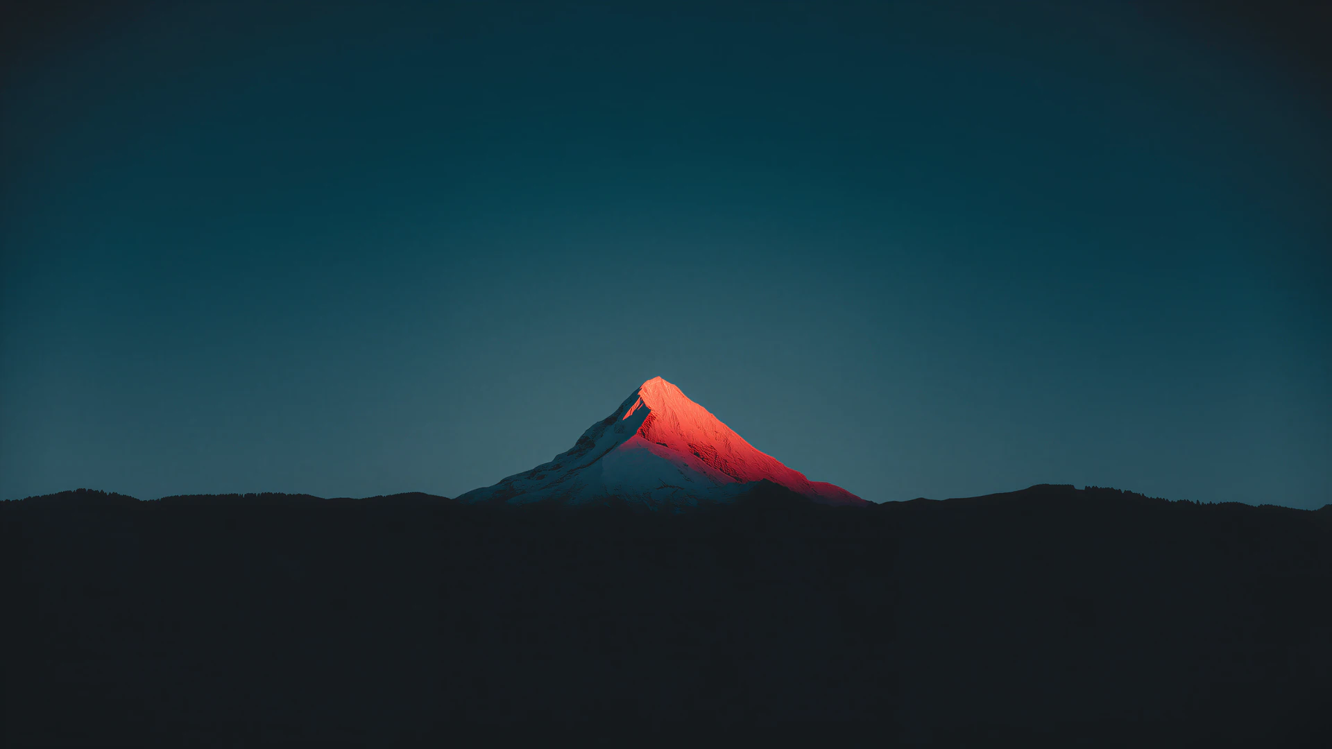 A solitary mountain glows red beneath a deep teal night sky. Dark ridges and smooth gradients create a dramatic, cinematic wallpaper.